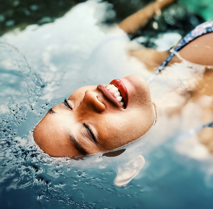 Smiling Relaxed Woman Floating In Water