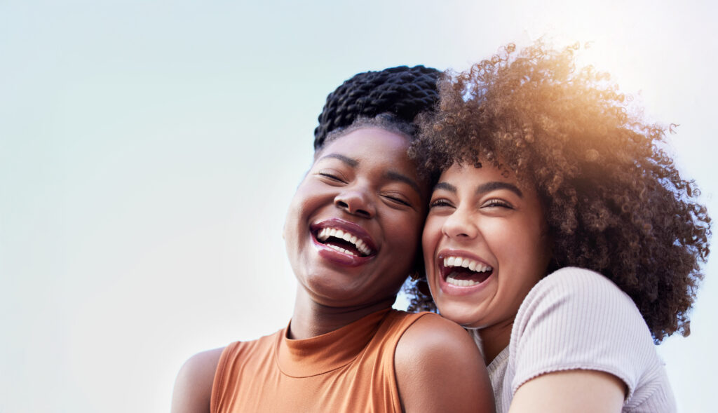 Two Young Women Smiling And Hugging